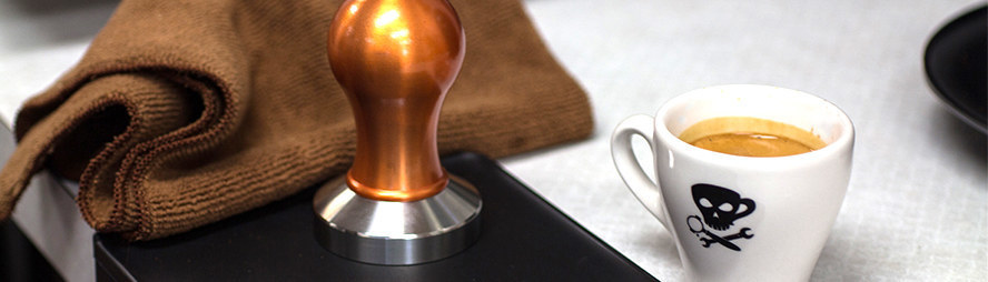 tamping espresso in a portafilter with a tamper from barista basics